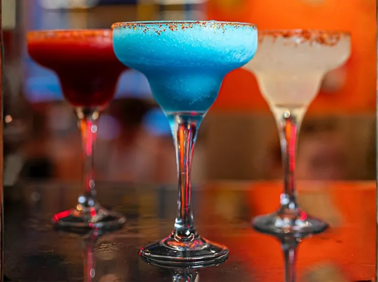 Tres margaritas frozen de El Rey de los Tacos —roja, azul y blanca— con borde de Tajín